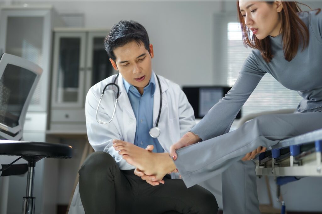 Doctor examining patient's Achilles tendon during follow-up appointment